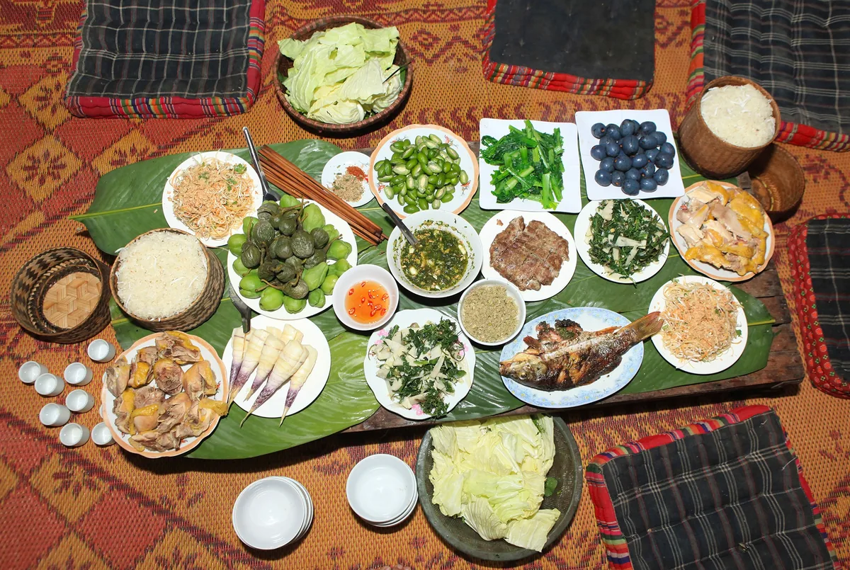 Mâm cỗ dân tộc Thái ở Sơn La với xôi, cá nướng, rau và các món ăn kèm bày trên lá chuối.
